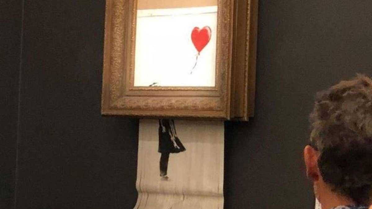 Banksy's painting self-destructs moments after it's sold for $1.4M