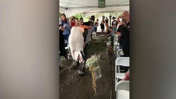Texas groom carries bride on his back down muddy aisle