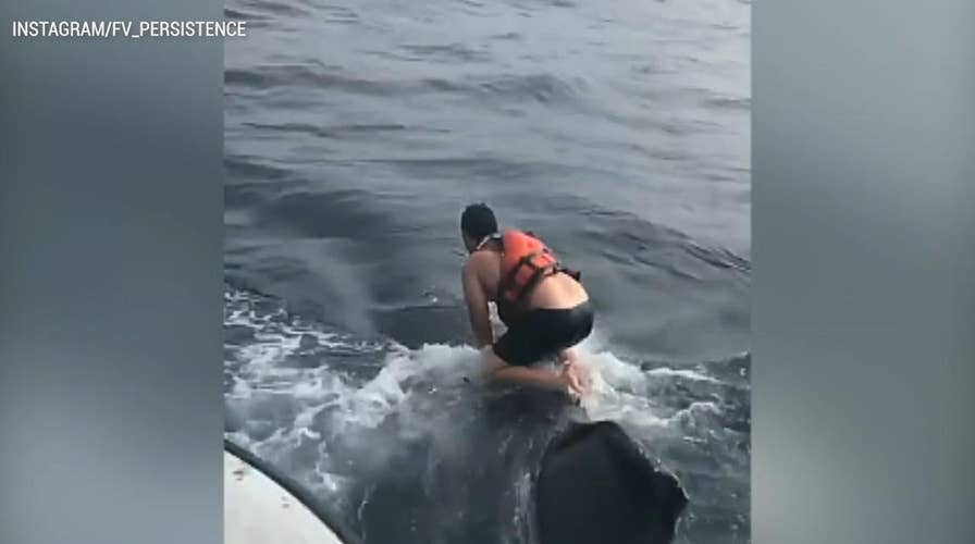 Fisherman jumps on humpback whale to free it from rope