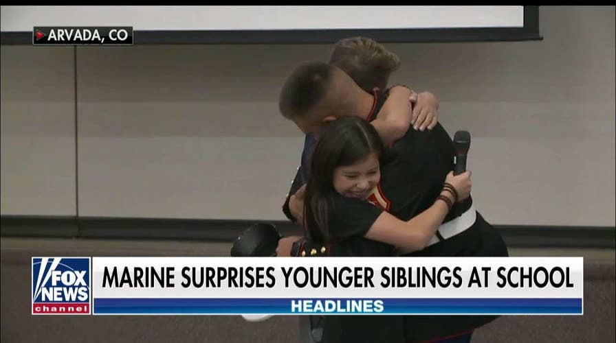 Marine surprises younger siblings at Veterans Day Assembly.