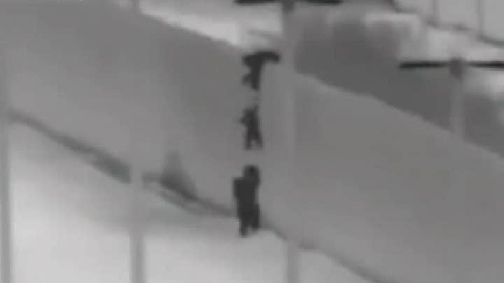 Migrant children seen being dropped over US border wall