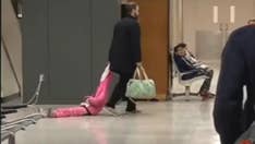 Dad dragging daughter through Washington Dulles airport by hood goes viral