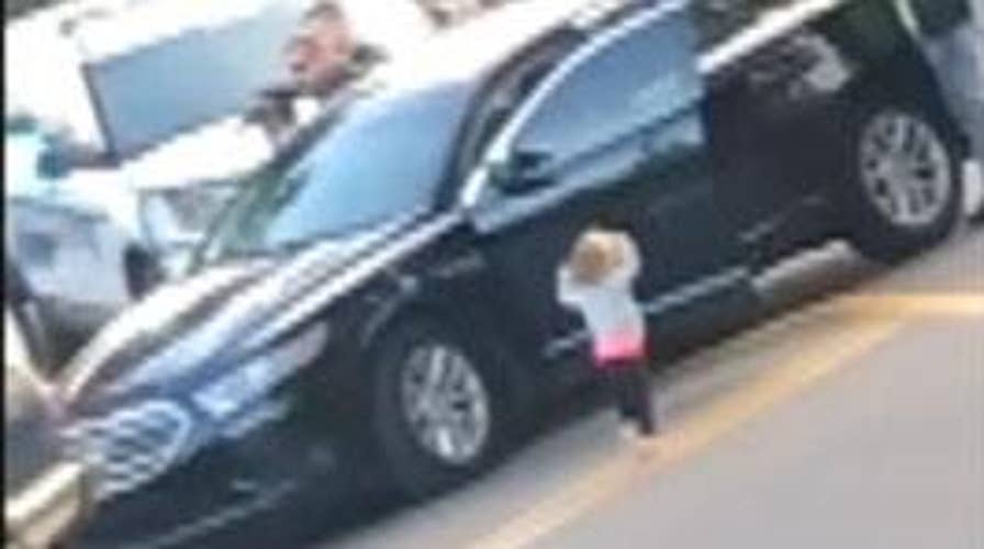Toddler exits vehicle with hands up following her parents