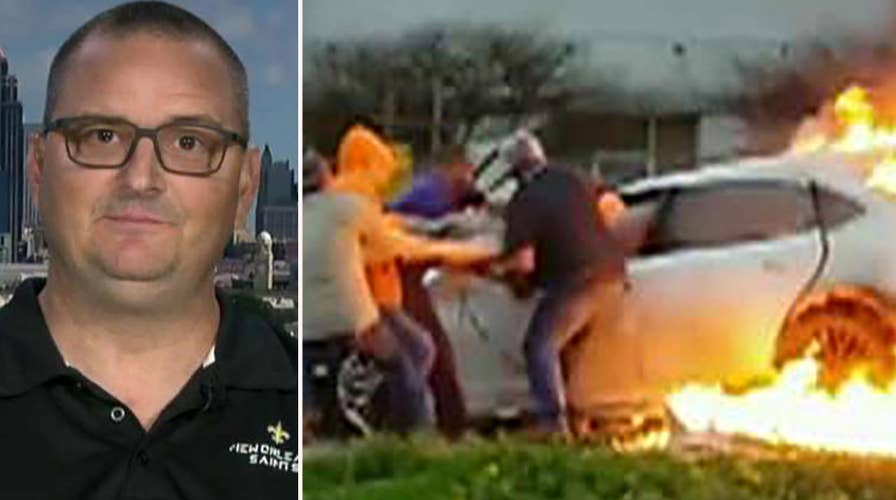 Woman trapped in a burning car rescued by four bystanders