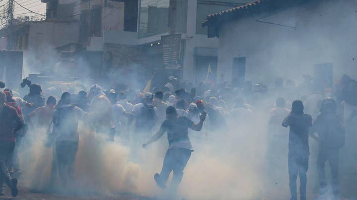 Police and protestors clash in Venezuela as citizens attempt to push foreign aid across the closed border