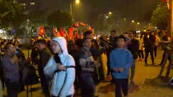 Crowds gather outside Trump's hotel in Vietnam to get a glimpse of the president