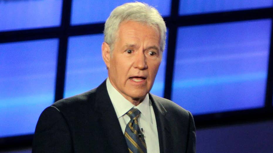 Fans, TV hosts and the famous "Jeopardy!" Candidates gather behind Alex Trebek