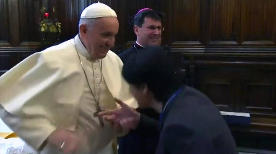 Pope Francis pulls hand away from worshippers wanting to kiss his ring
