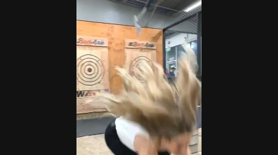 Woman at indoor entertainment center narrowly dodges ax playing popular game