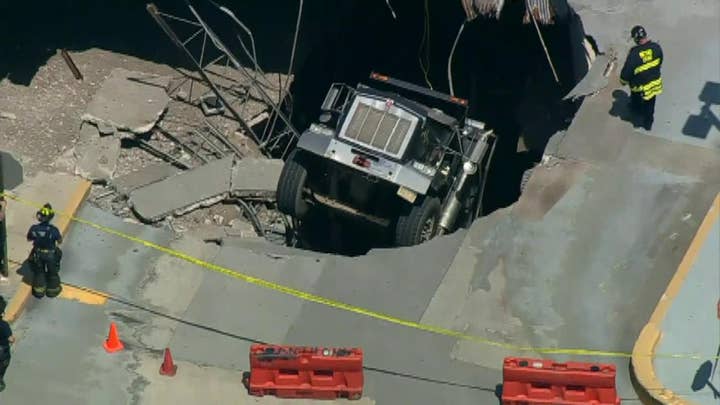 Raw video: Officials cordon off hole where a truck has fallen through the roof of a parking structure
