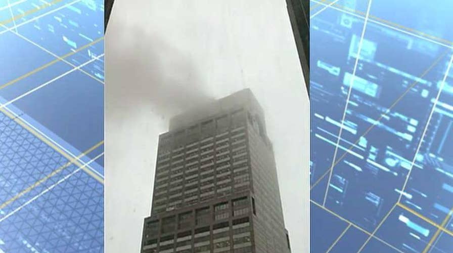 Amateur cell phone video captures smoke from Manhattan high-rise rooftop after helicopter crash-landing