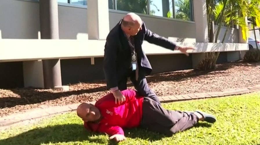 Australian police detective stops news conference to tackle man