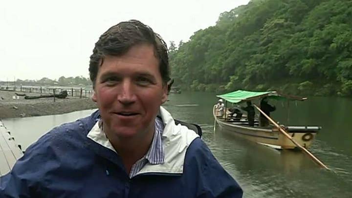 Tucker Carlson makes it back to land after a boat ride in Kyoto, Japan