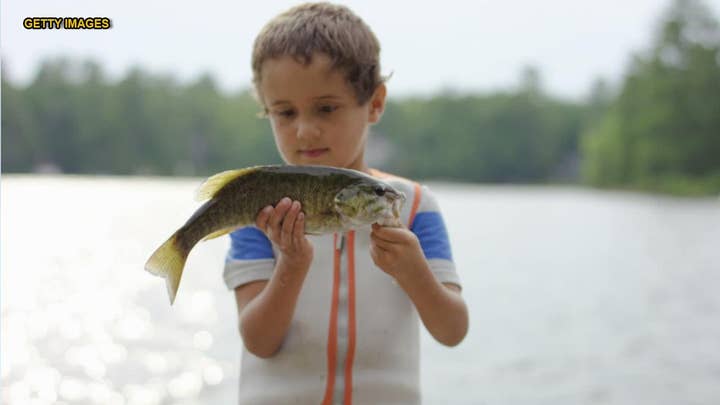 Mom doesn't realize kid shoved a fish in his mouth in family photo