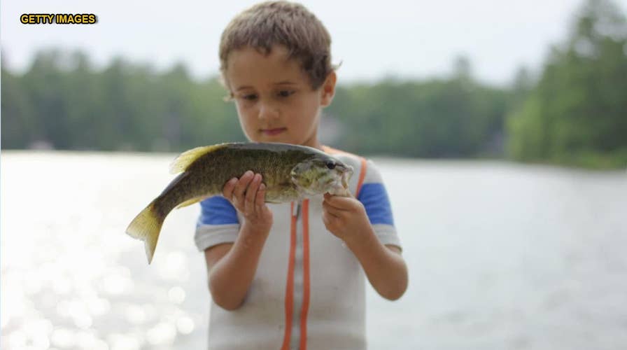 Mom doesn't realize kid shoved a rubber fish in his mouth in family photo