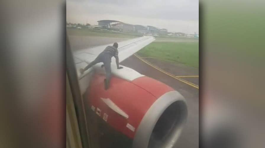 Raw video: Intruder climbs onto the engine of a plane just before takeoff from Nigeria's busiest airport