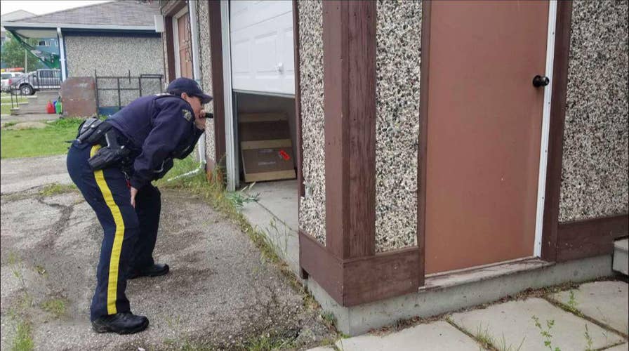 Canadian police conduct door-to-door search for suspects in murder of an American and two others