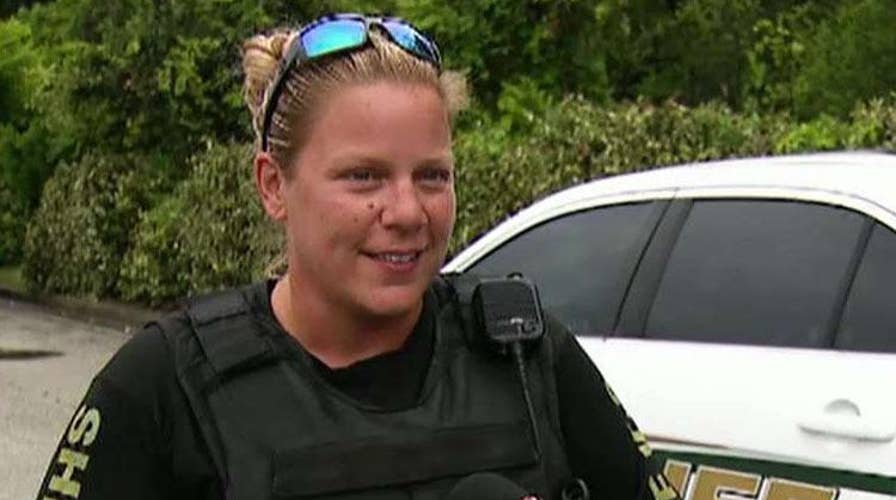 Deputy picks up and folds a fallen American flag