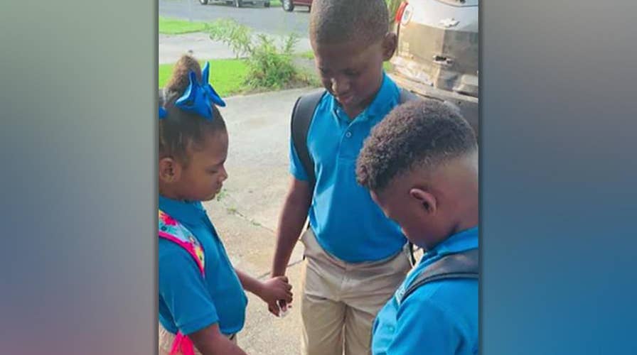 Photo of siblings praying on first day of school goes viral as family faces tough times