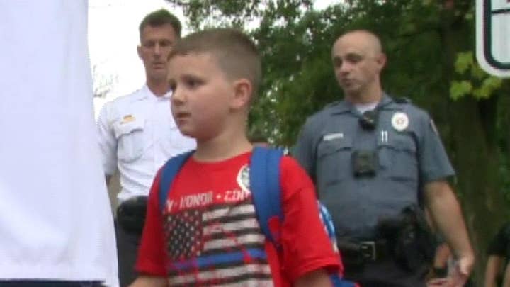 Police officers walk fellow officer's autistic son to his first day of school