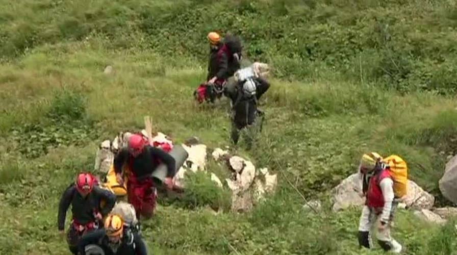 Dozens of rescuers search for two people trapped in Poland's deepest, longest cave