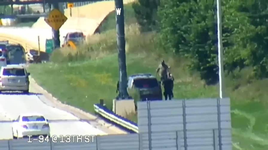 Three men seen riding scooters along highway