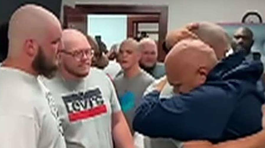 Football players shave heads for coach battling cancer