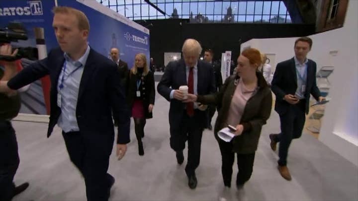 UK PM Boris Johnson handed cup by aide, has it taken by another aide