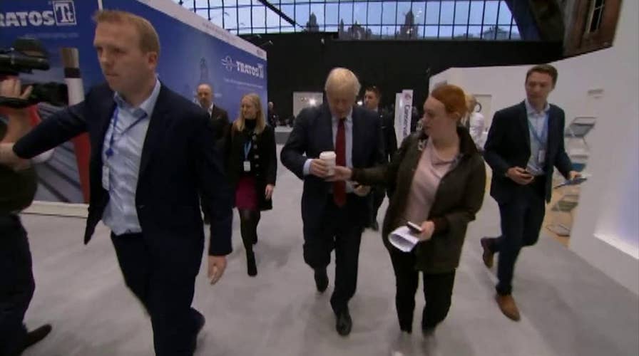 UK PM Boris Johnson handed cup by aide, has it taken by another aide