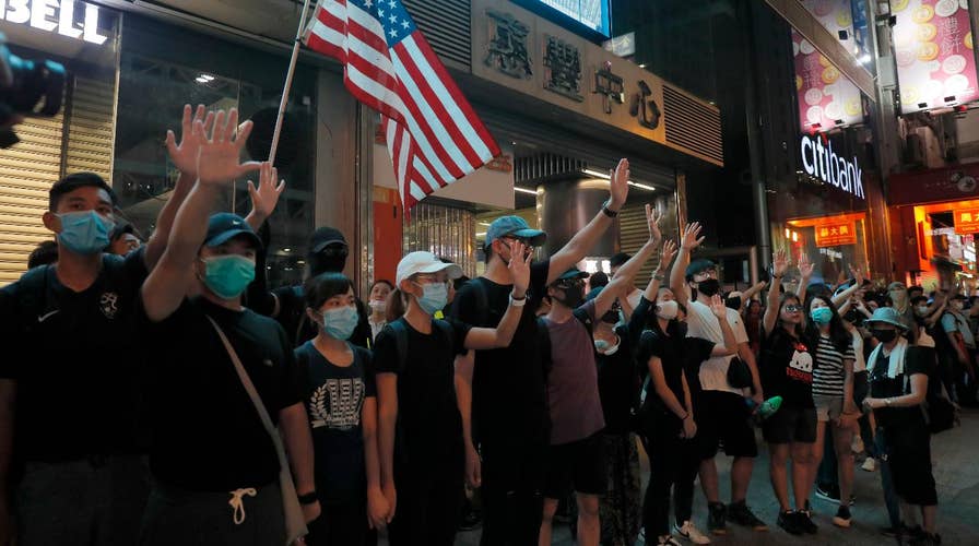 Hong Kong demonstrators wear face masks in defiance of ban in 2019 report produced by Baz Davies