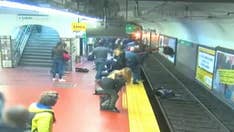 Argentina commuters rescue woman pushed onto tracks in front of oncoming train in harrowing video