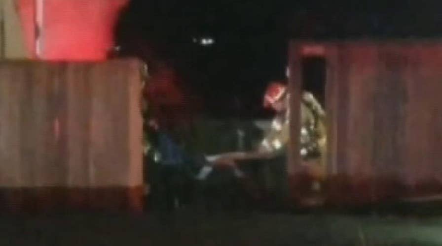 Firefighters battling two-alarm blaze take a moment to rescue an America flag