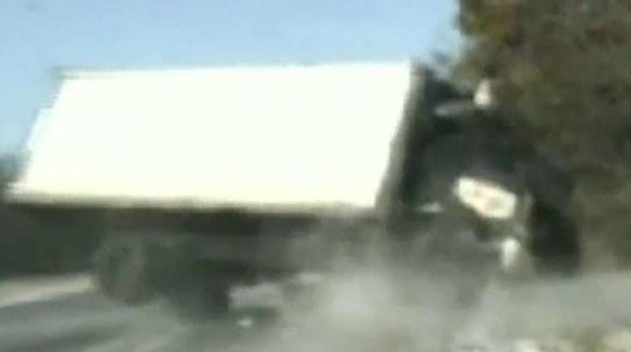 Runaway truck narrowly misses state troopers helping woman change tire on side of road