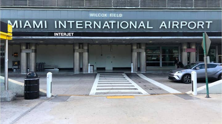 Naked woman seen wandering Miami airport, jumping off roof of police car