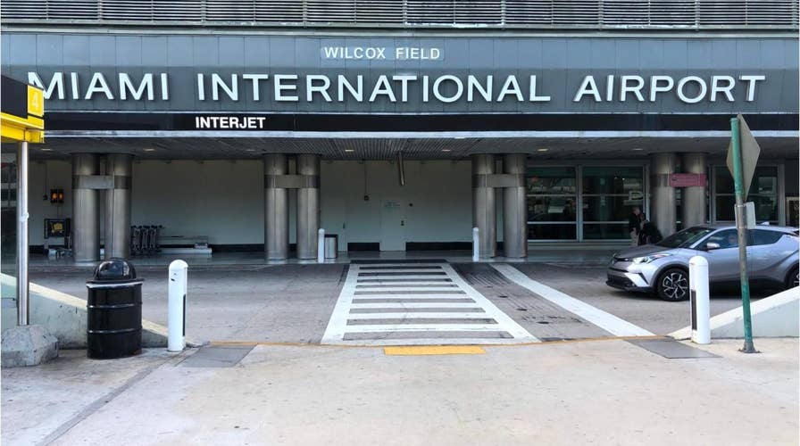 Naked woman seen wandering Miami airport, jumping off roof of police car