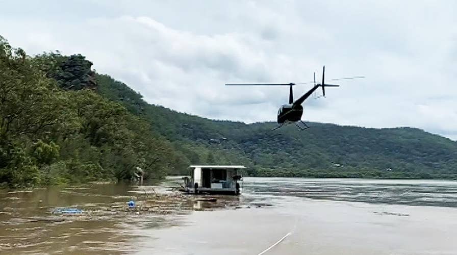 Helicopter lands on houseboat to help with water rescue in Australia