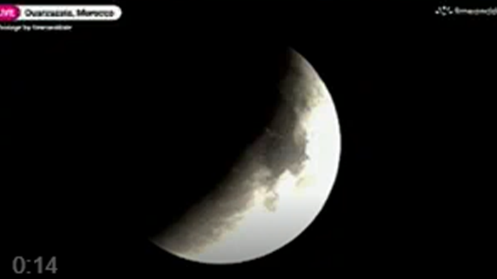 A blood moon lunar eclipse shines in the night sky