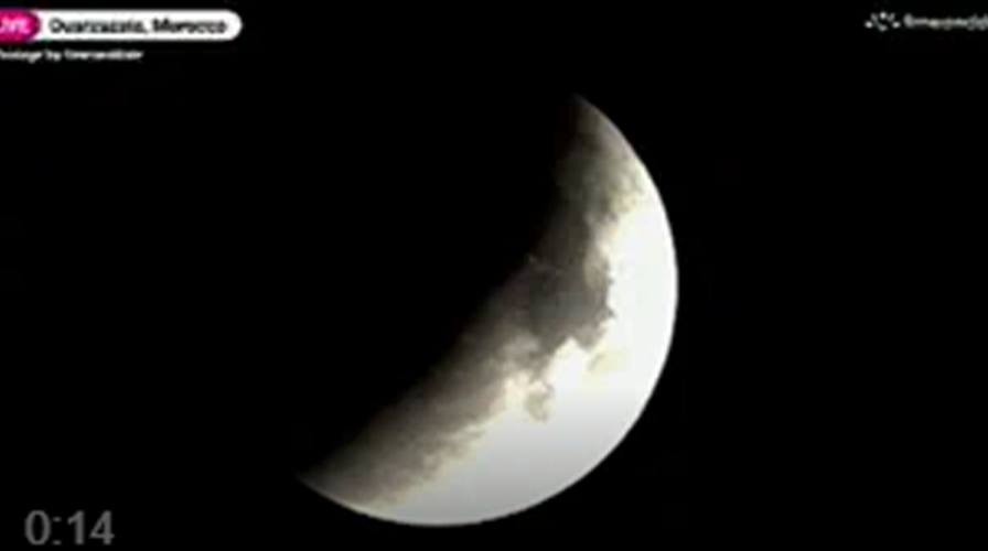 A blood moon lunar eclipse shines in the night sky