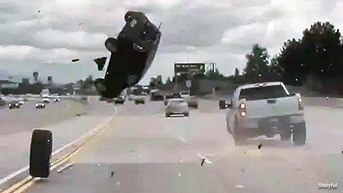 SEE IT: Car goes airborne on freeway after tire pops off pickup truck