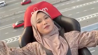 Thrill-seeker strapped in chair eats meal while hovering high above traffic - Fox News