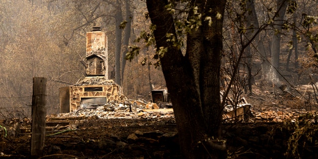 A chimney stands at a home destroyed by the McKinney Fire on Tuesday, Aug. 2, 2022, in Klamath National Forest, Calif.
