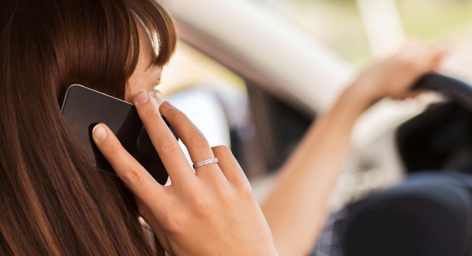 woman using phone while driving the car