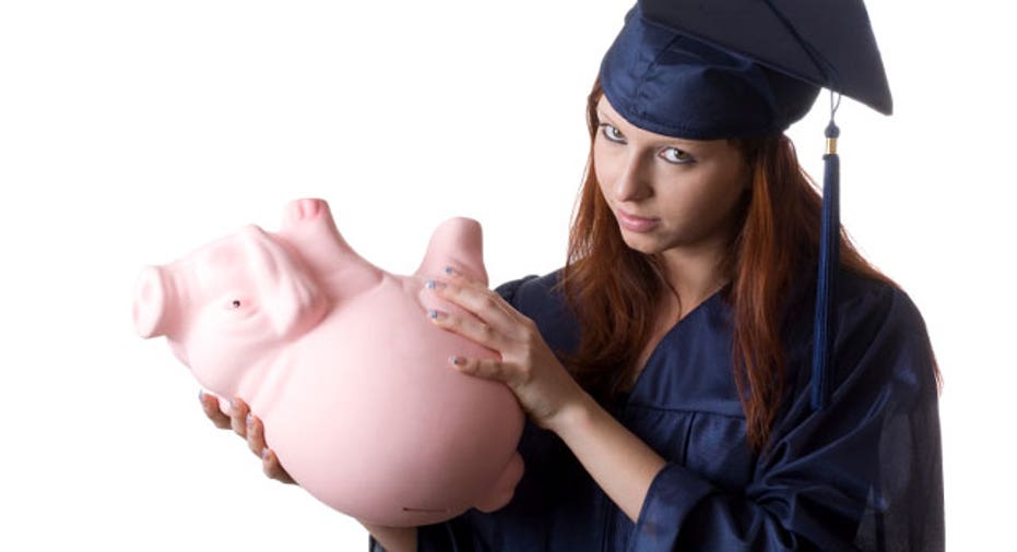 Graduate Holding Empty Piggy Bank