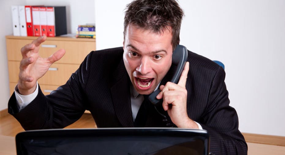 Man Angry at Computer on Phone in Office