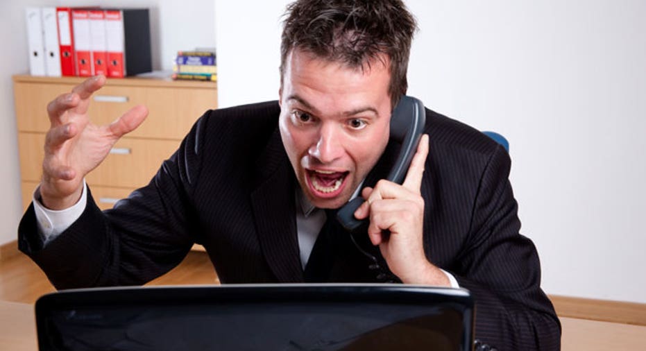 Man Angry at Computer on Phone in Office