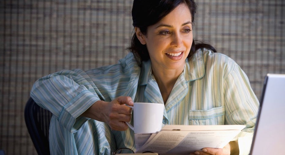 Hispanic businesswoman working in pajamas