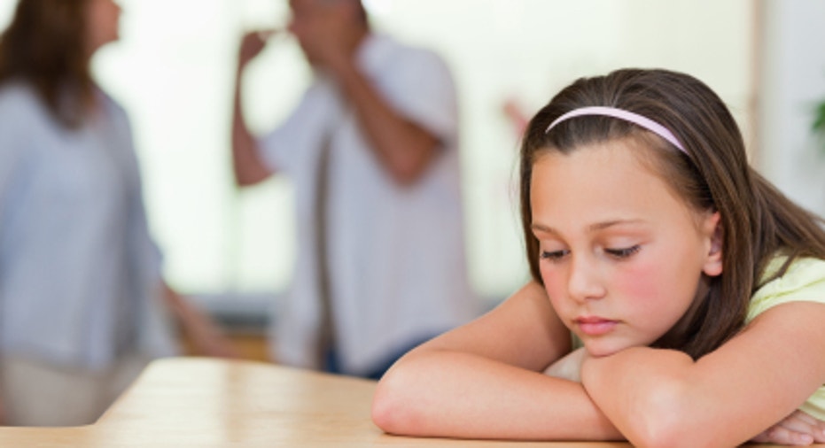 Sad girl with her fighting parents behind her