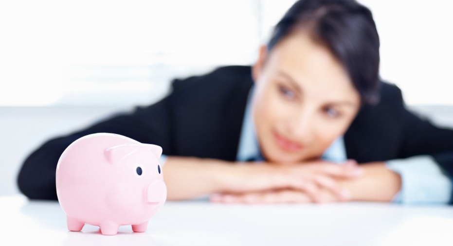 Smiling business woman with a piggybank