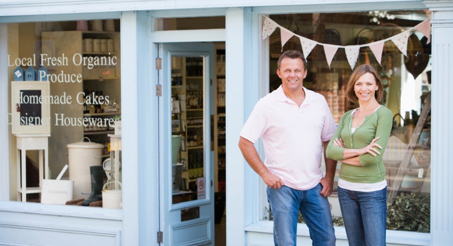 Couple standing in front of organic food store smiling