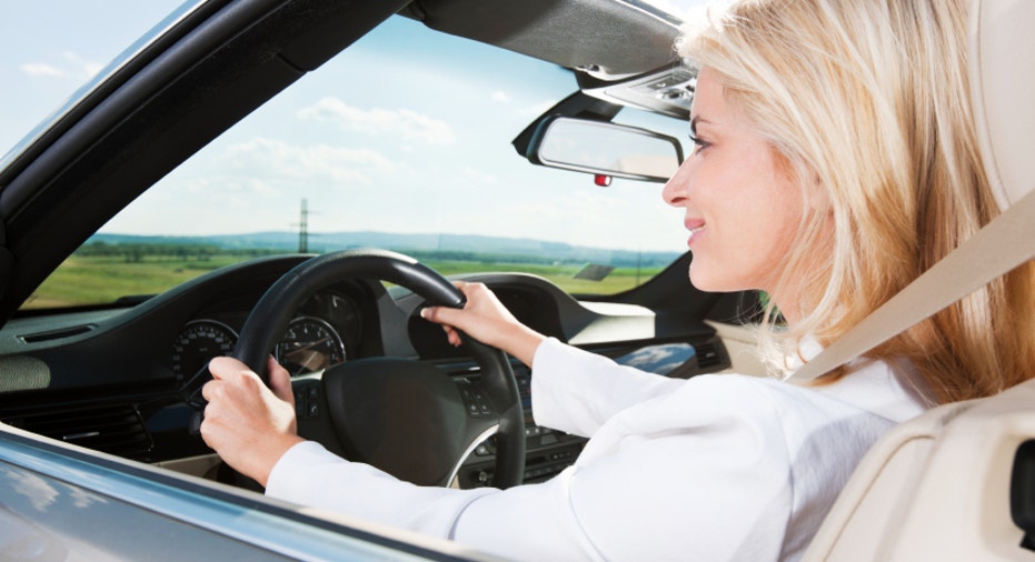 Smiling young woman driving a car.